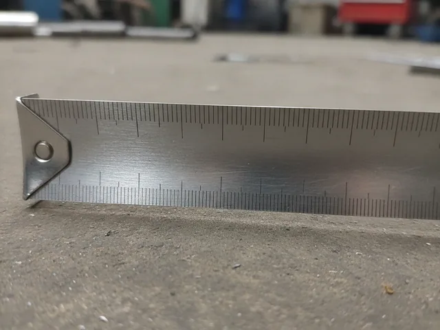 Steel rule laid across a seat base during a dimensional check